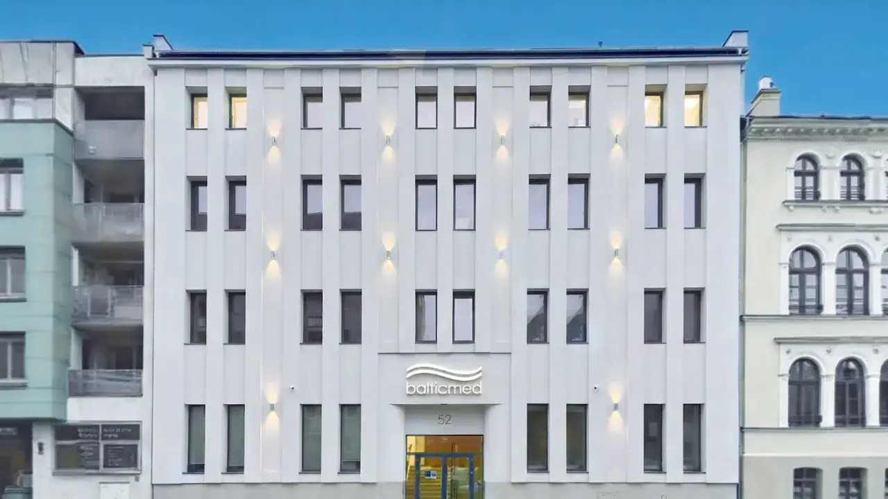 Nowoczesny, biały budynek kliniki Balticmed w Szczecinie z podświetlanym logo i oknami.