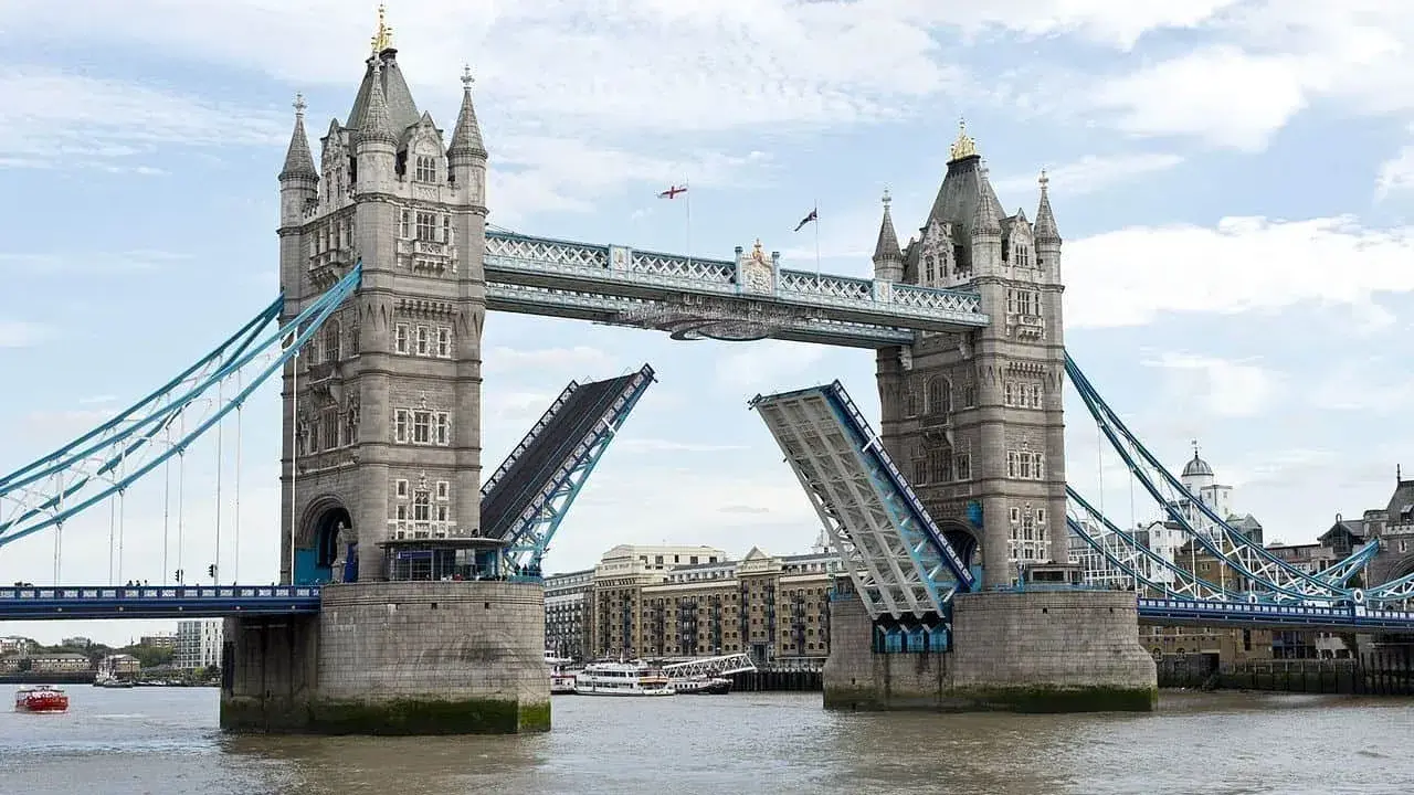 Torre de Londres con sus **puentes levadizos** abiertos, permitiendo el paso de barcos por el río Támesis.