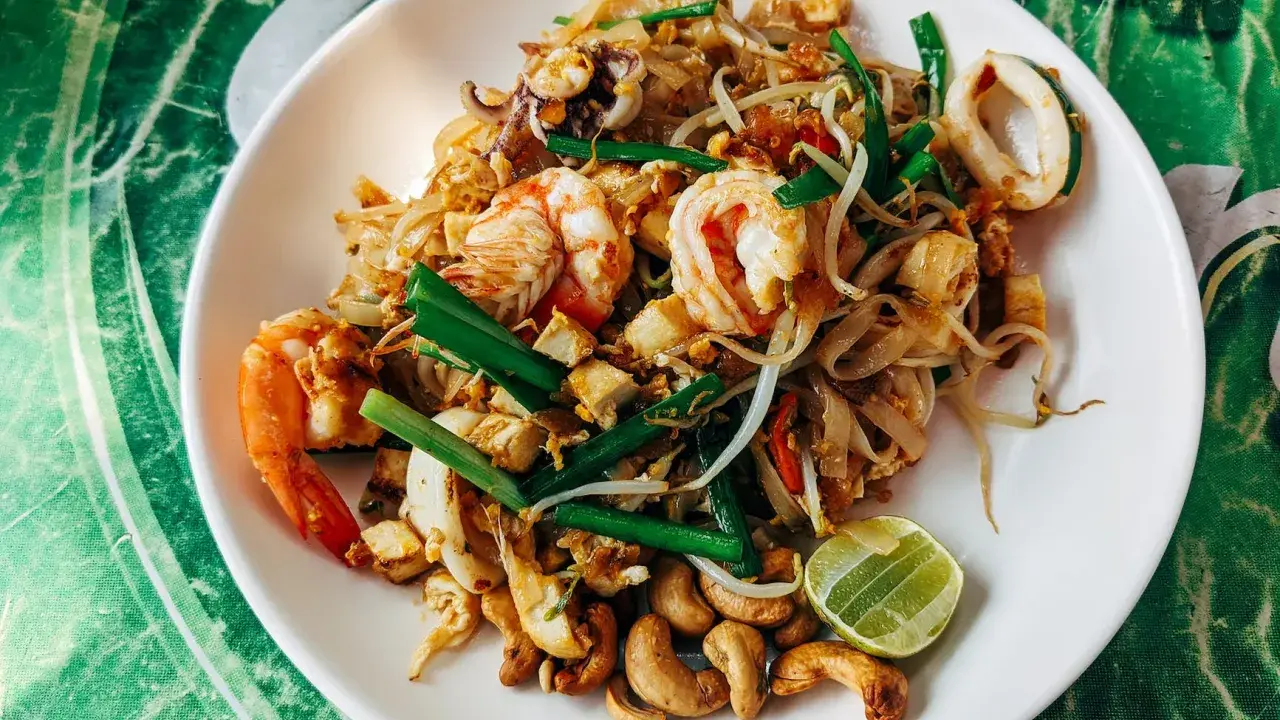 Pyszny pad thai przepis z krewetkami, kalmarami, kiełkami i orzechami nerkowca.