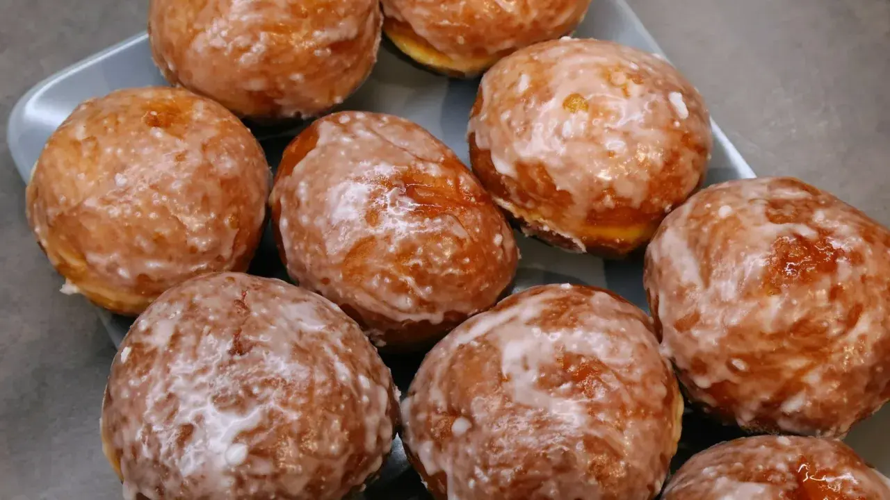 Puszyste pączki z piekarnika, oblane lukrem, kuszą swoim wyglądem. Idealne na tłusty czwartek lub jako słodka przekąska.