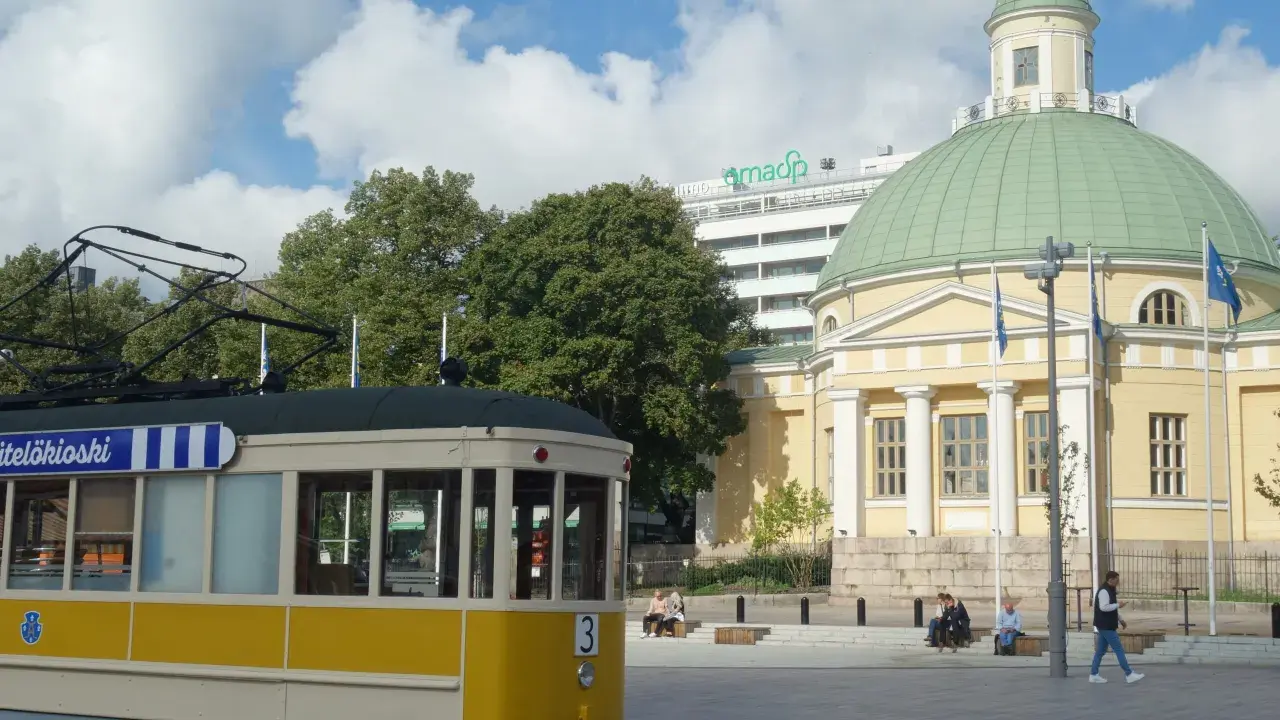 Żółty tramwaj na tle katedry i nowoczesnego budynku. Turku atrakcje to nie tylko zabytki, ale i miejska komunikacja.