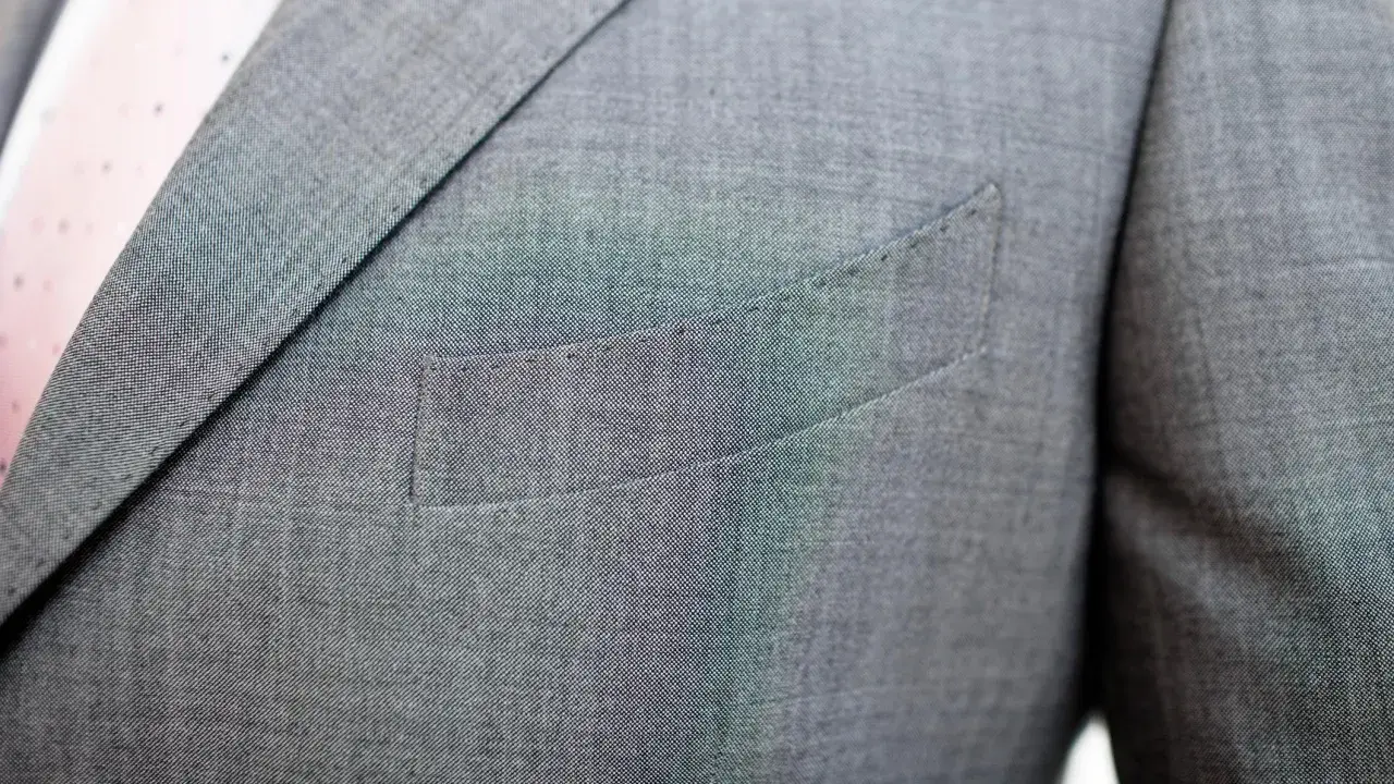 A suit jacket's breast pocket is sewn shut. This is often done to maintain the jacket's crisp silhouette, as why are pockets sewn shut is a common question for new suit owners.