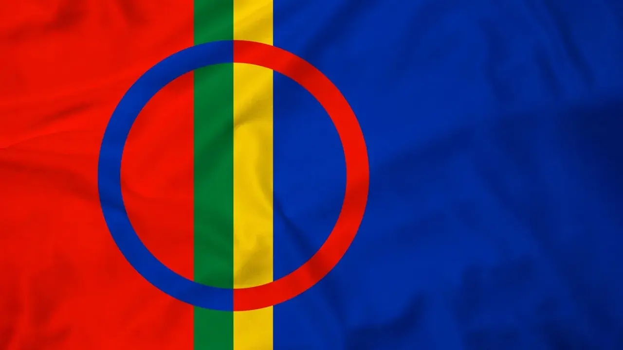 Sápmi-flaggan med sina färger rött, grönt, gult och blått, samt cirkeln som symboliserar solen och månen.