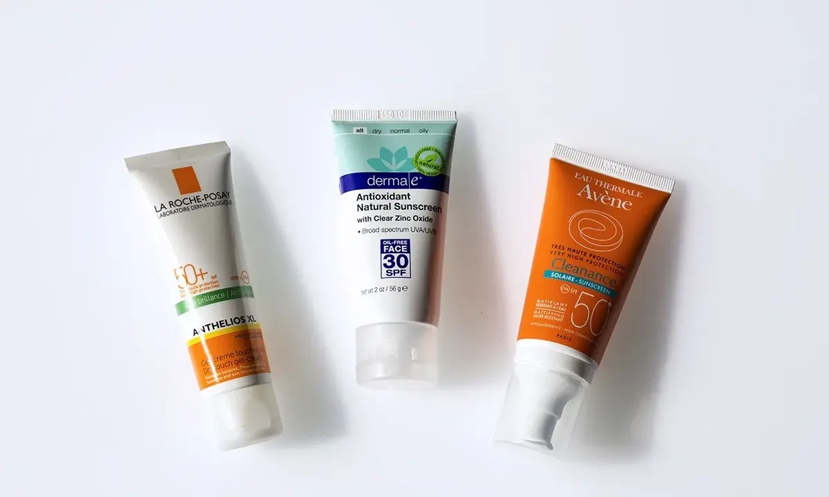 Trois tubes de crème solaire (La Roche-Posay, Dermale, Avène) pour montrer à quoi sert la crème solaire : protéger la peau des rayons UV.
