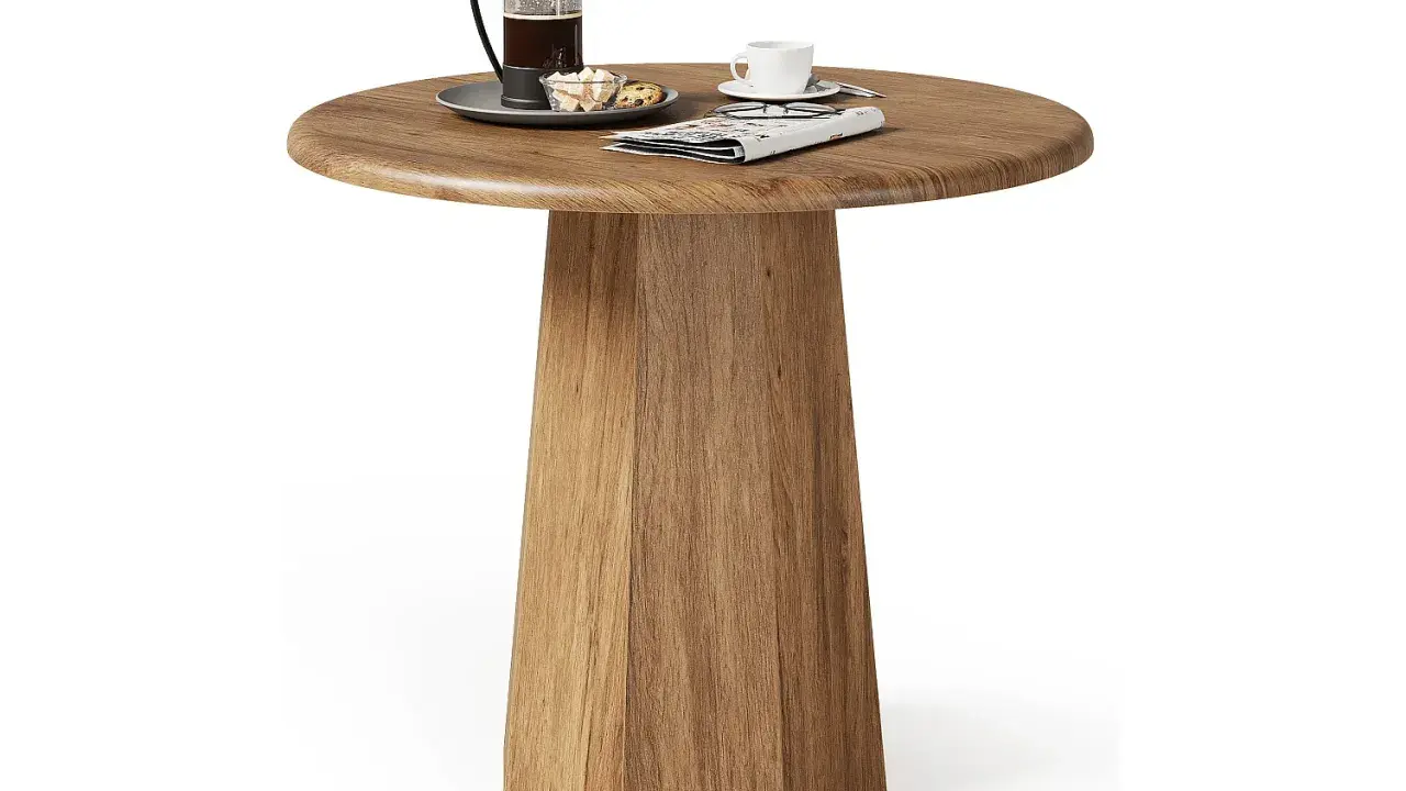 Ett runt, träfärgat litet slagbord med en kaffepress, en kopp och en tidning.
