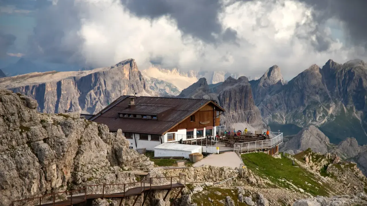 Rifugio alpino in Alto Adige, con sentiero metallico e imponenti vette sullo sfondo.