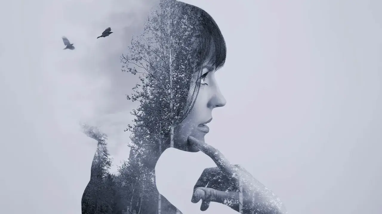 Silueta de mujer pensativa en **doble exposición**, con un bosque y dos cuervos volando.