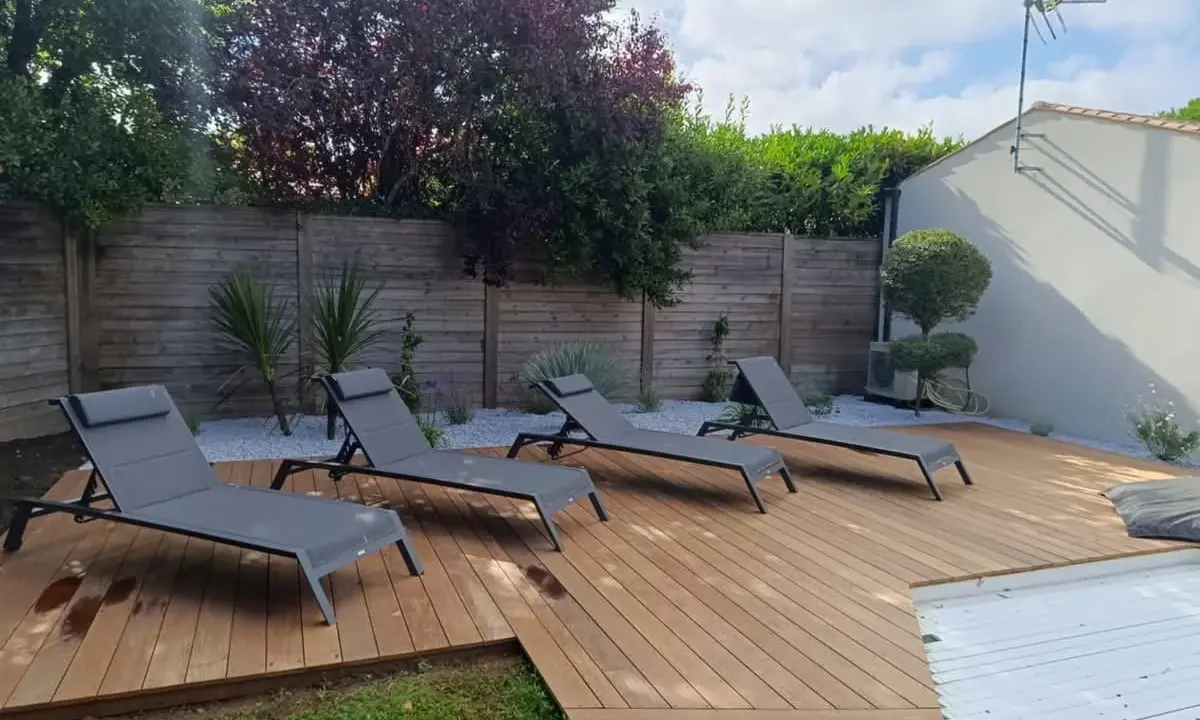 Aménagement terrasse en bois avec chaises longues invitant à la détente. Un espace extérieur parfait pour profiter du soleil.