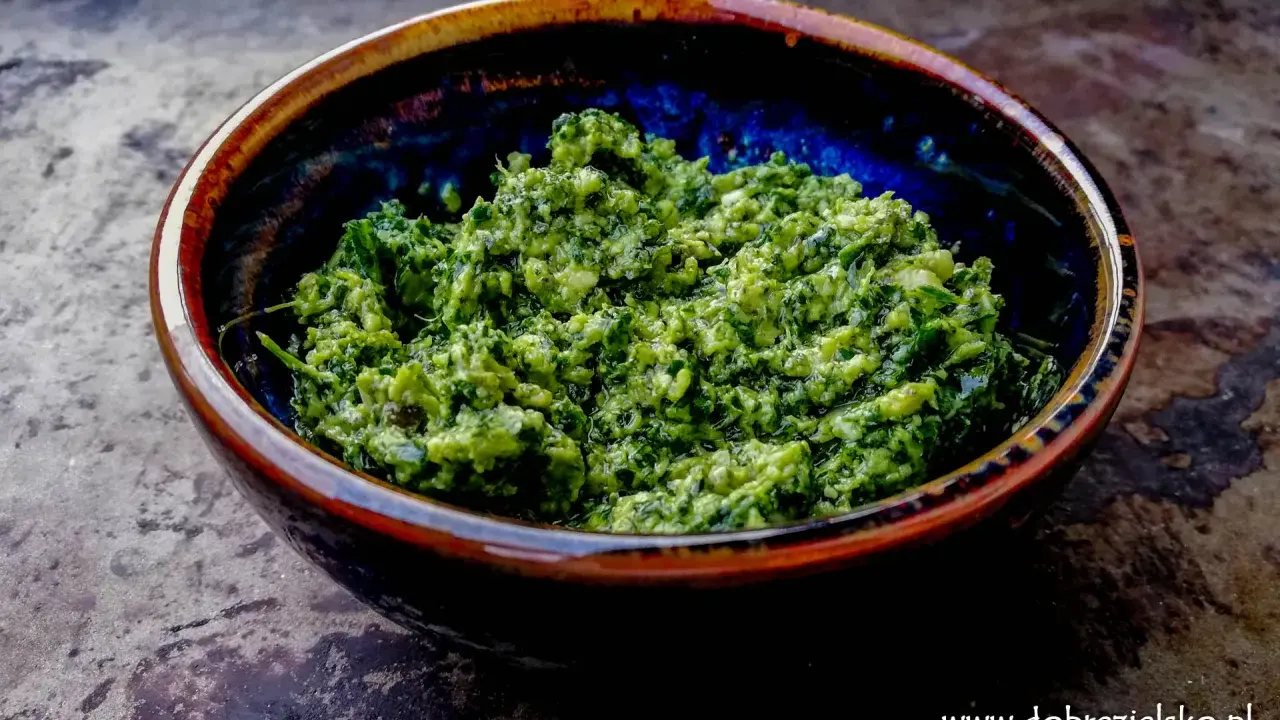 Domowe pesto z bazylii i czosnku, z dodatkiem orzechów, w ceramicznej misce. Idealne do makaronu. Jakie orzechy do pesto?
