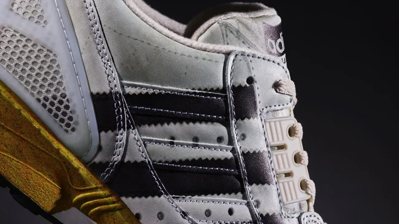 Detailaufnahme des Adidas ZX 8000 Release. Der Schuh zeigt die charakteristischen Streifen und eine goldene Sohle.