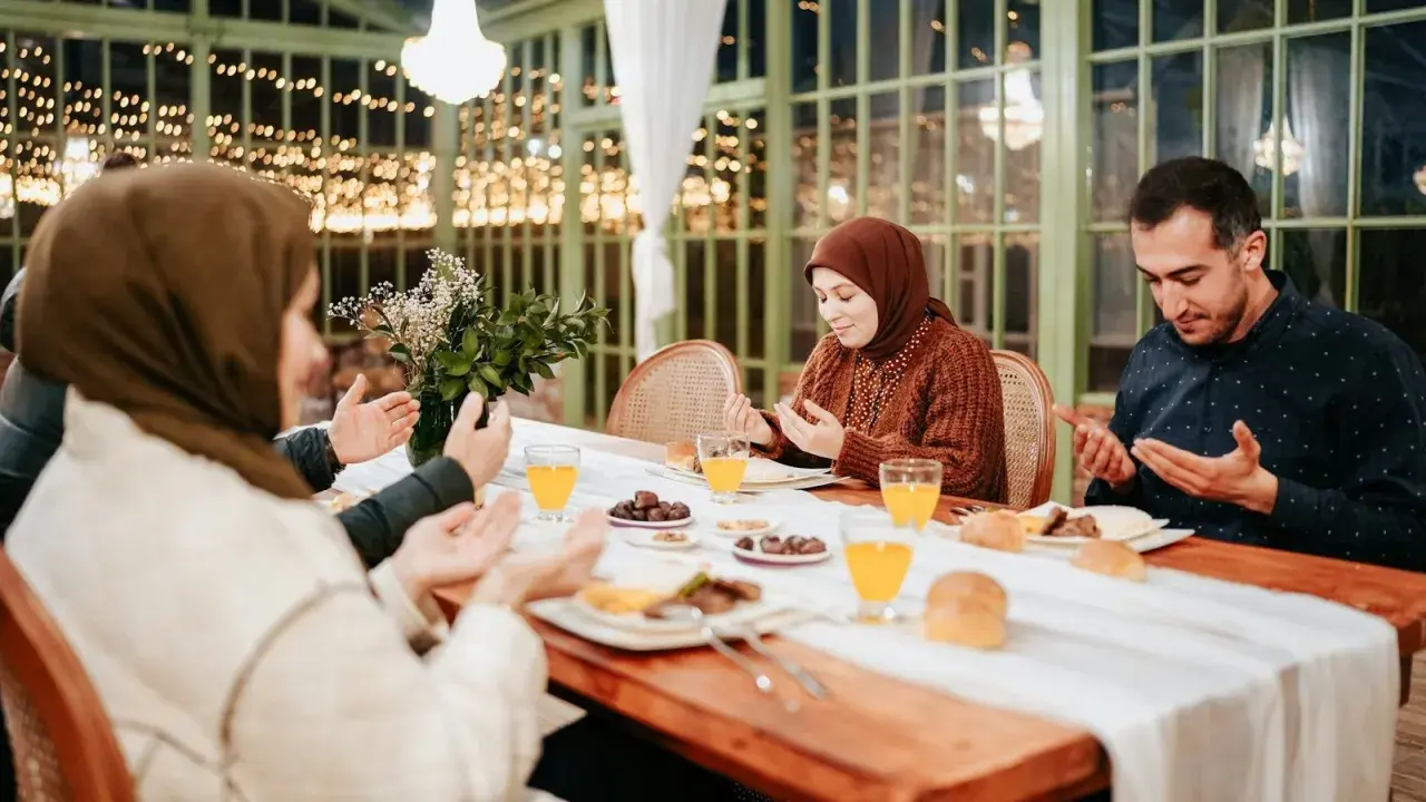 Familie betet vor dem Iftar. Sie fragen sich, was sagt man wenn man fasten will, bevor sie essen.