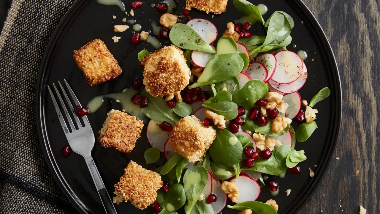 Feldsalat mit Radieschen, Walnüssen, Granatapfelkernen und knusprig panierten Käseecken.
