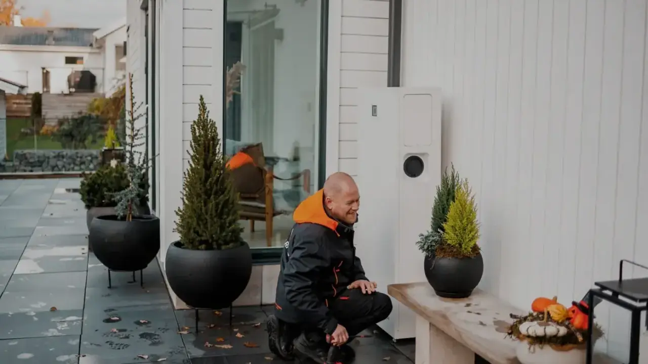 Tekniker arbetar med en värmepump, en del av ett eco kraft-system för ett modernt hem.