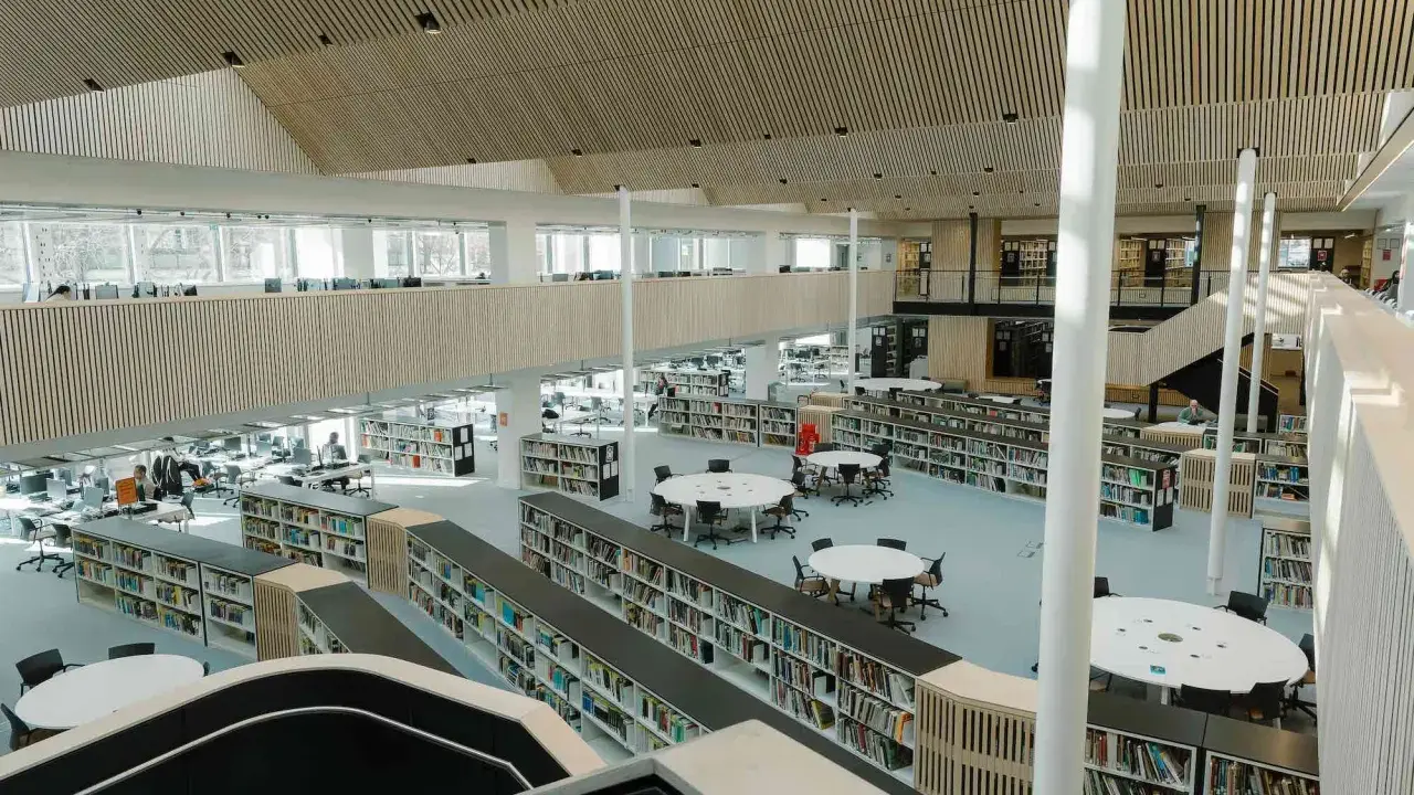 Storslagen biblioteksmiljö med bokhyllor, läsplatser och en modern arkitektur. Här kan man hitta aaltos recensioner bland tusentals böcker.