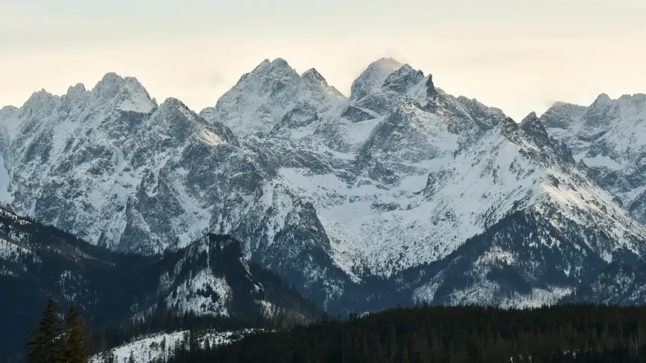Śnieżne szczyty Tatr, prawdziwa korona gór polskich, lśnią w zimowym słońcu.