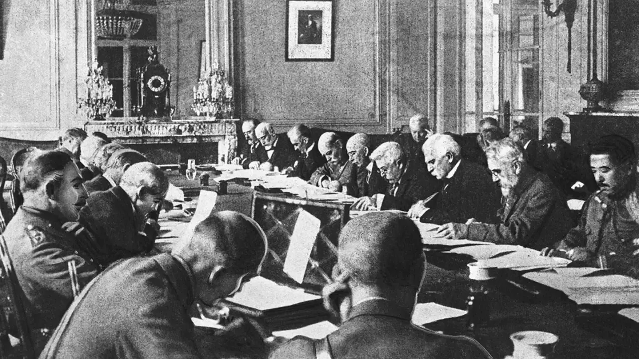 Männer in einem prunkvollen Raum diskutieren den Inhalt des Versailler Vertrags.