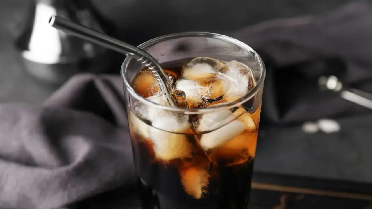Erfrischender Cold Brew Kaffee in einem Glas mit Eiswürfeln und einem Metallstrohhalm. Perfekt für heiße Tage.