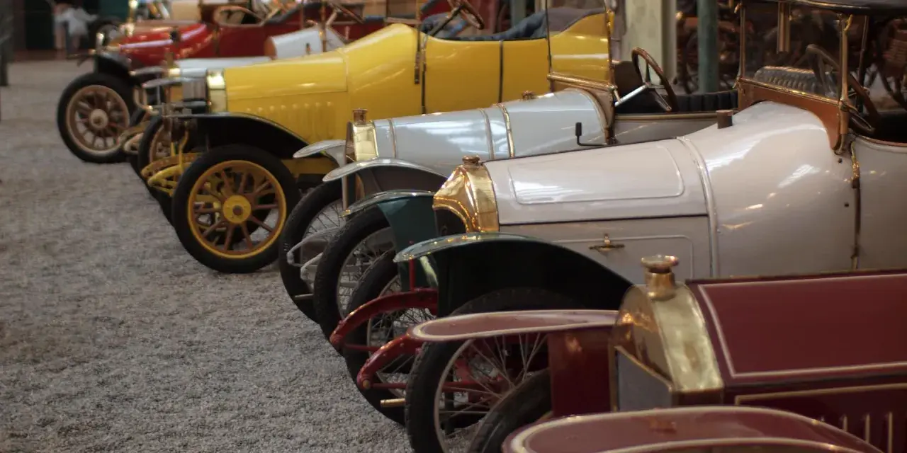 Reihe von Oldtimern, von denen jeder einen hohen schlumpf autosammlung wert hat. Gelb, weiß und rot sind die dominanten Farben.