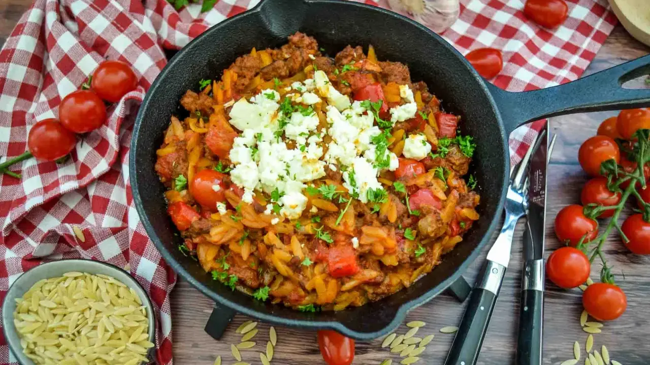 Herzhaftes Kritharaki-Gericht mit Hackfleisch, Tomaten und Feta in einer Gusseisenpfanne. Perfekt für leckere Kritharaki Rezepte.