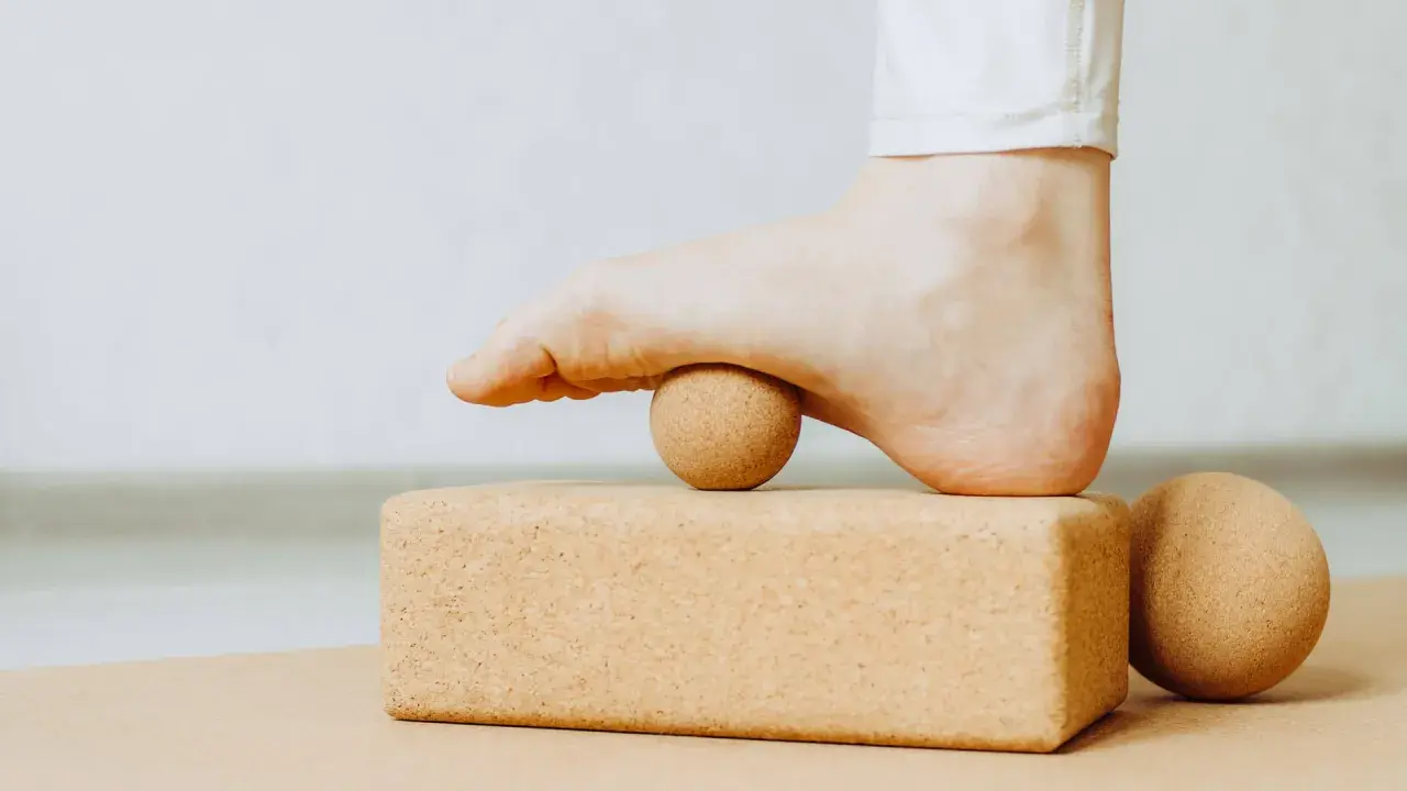 Fuß mit Ball auf Korkblock für Plantarfasziitis Dehnen.