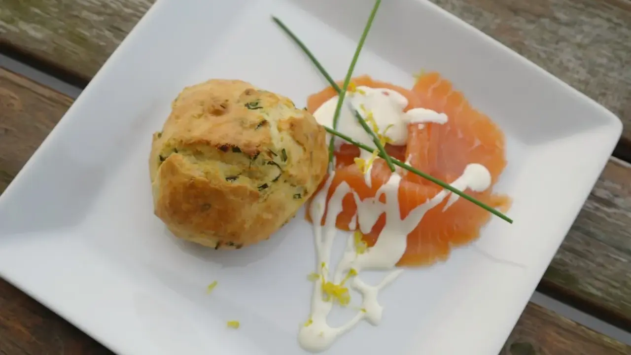 Matiga muffins med örter serveras med gravad lax, en klick gräddfil och citronzest.