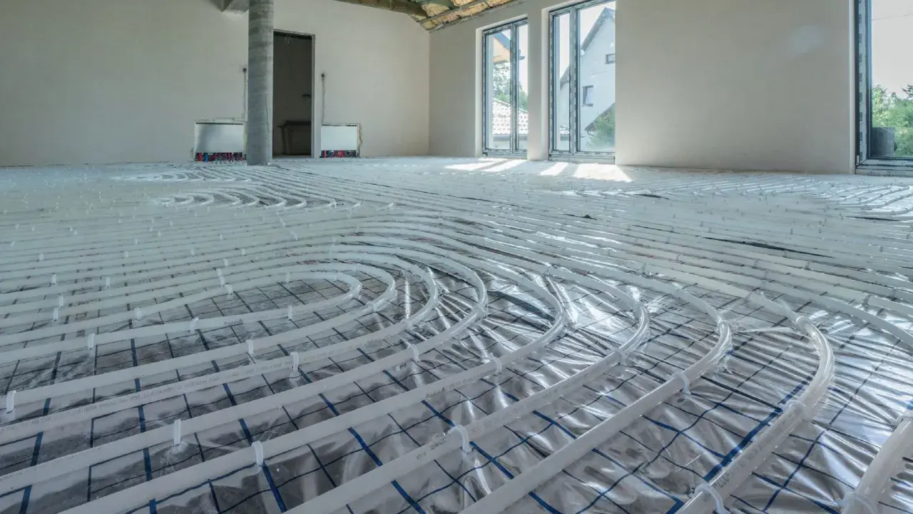Rozłożone rury do ogrzewania podłogowego wodnego w nowym domu. Instalacja gotowa do zalania wylewką.