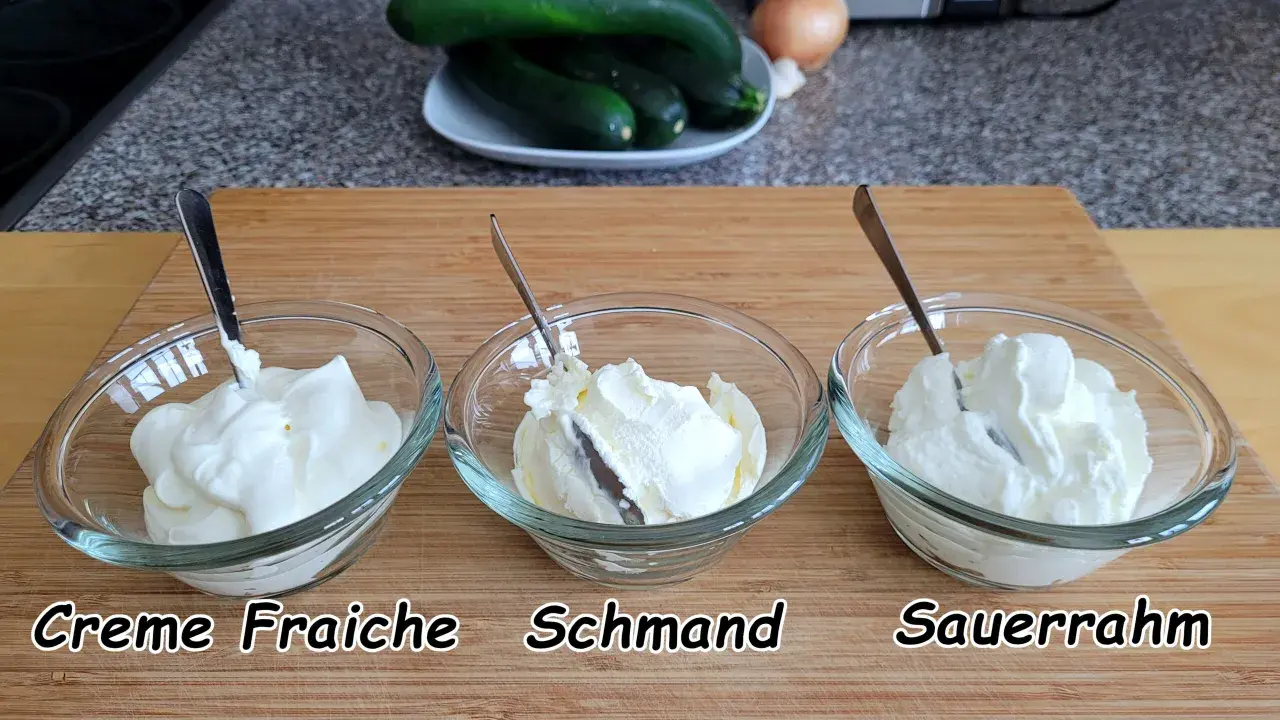 Drei Schüsseln mit cremigem Frischkäse: Crème Fraîche, Schmand und Sauerrahm. Perfekt für deutsche Rezepte.