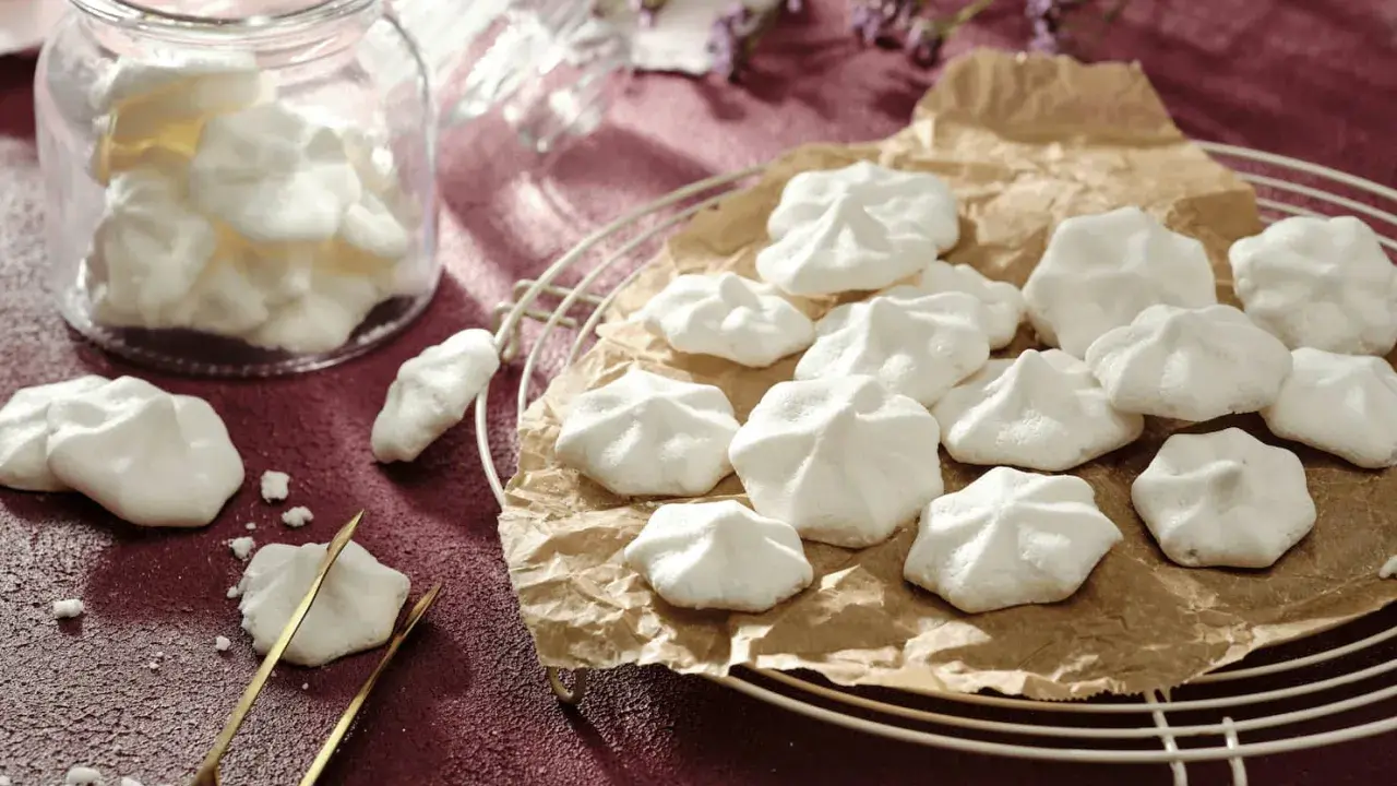 Luftige Baiser-Häppchen, perfekt für vegane aquafaba rezepte. Ein Glas voller süßer Leckereien und ein paar auf einem Gitter.