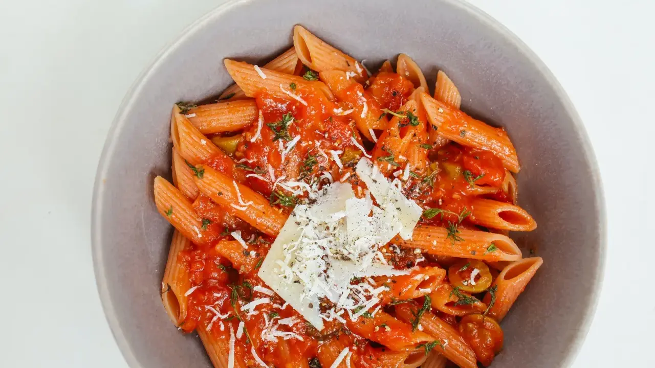 Penne w sosie pomidorowym z ziołami i parmezanem. Idealny przepis na zdrowy makaron, który zachwyci smakiem.