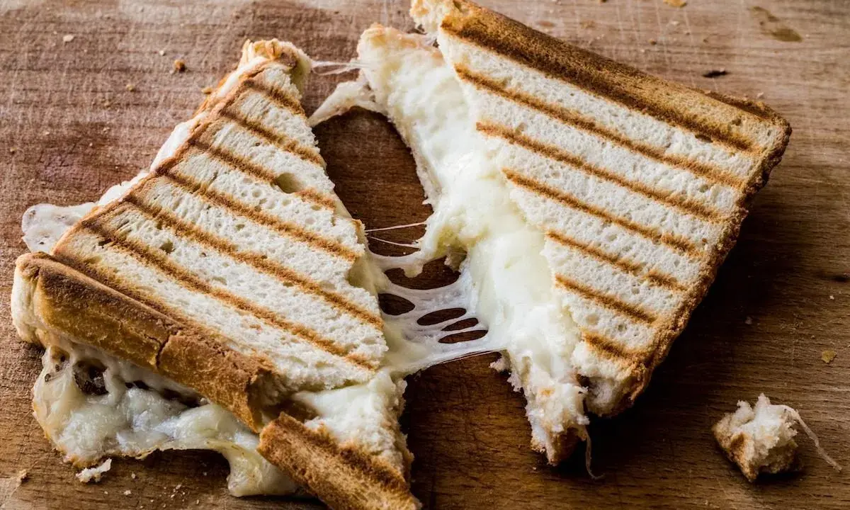 Pyszny, ciągnący się ser w tostach. Zastanawiasz się, ile kcal ma tost z serem? Ten wygląda na około 300-400 kcal.