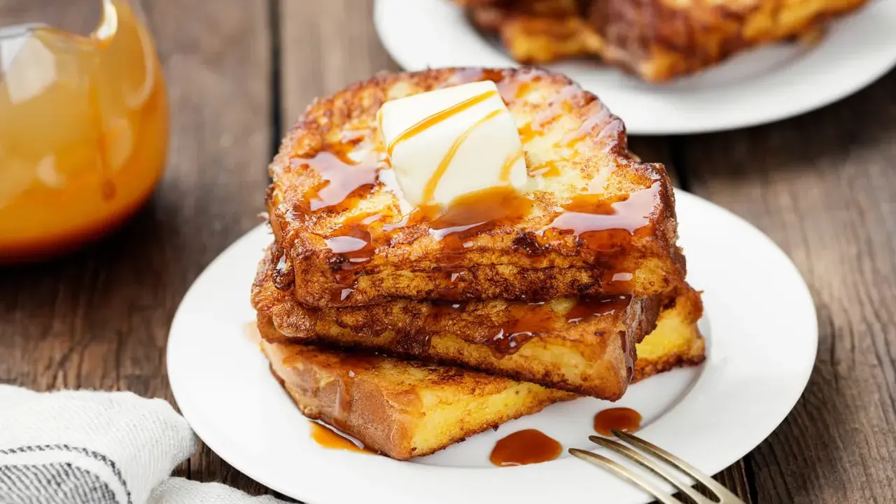 Pile de pain perdu salé doré, nappé de sirop et garni de beurre fondant. Un délice pour le petit-déjeuner.