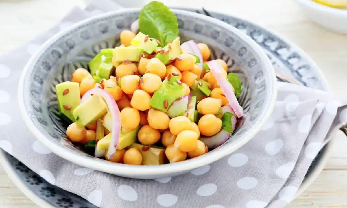 Deliciosa ensalada de garbanzos y aguacate, con cebolla morada y semillas de lino. Fresca y nutritiva.