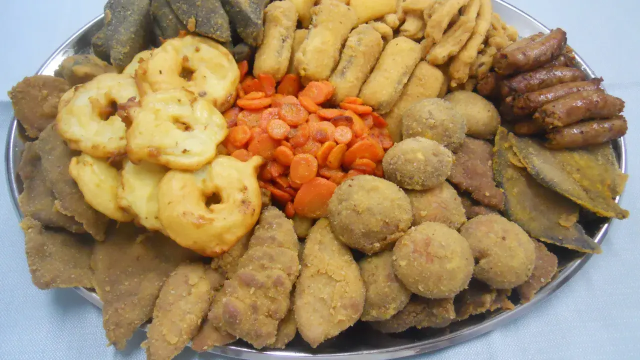Vassoio con vari piatti tipici torinesi: frittelle, verdure, polpette e salumi.