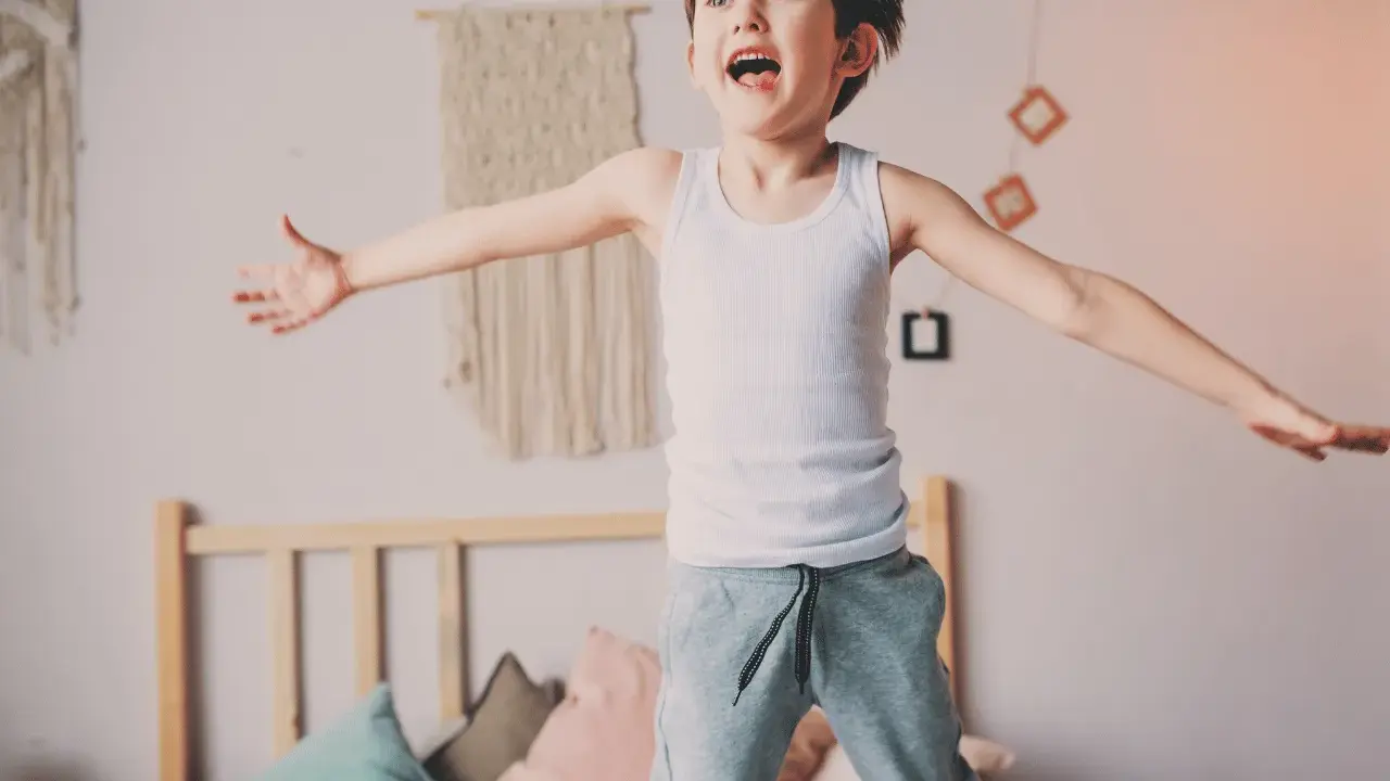 Bambino iperattivo 4 anni cosa fare? Un bimbo salta sul letto, pieno di energia.