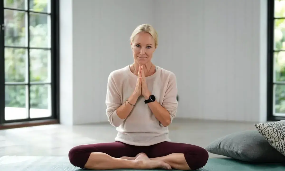 Kvinna i lotusställning på yogamatta, redo för yoga meditation.