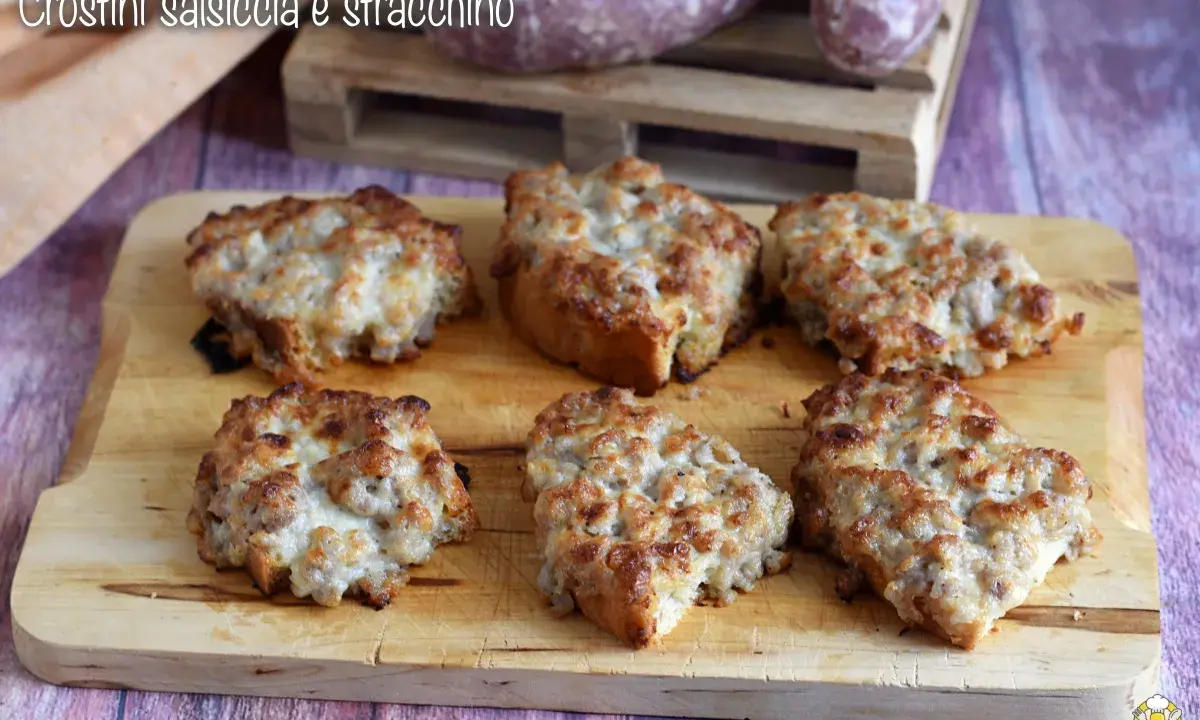 Sei crostini salsiccia e stracchino dorati e filanti, pronti per essere gustati.