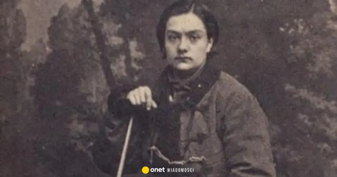 Portret Anny Pustowójtówny w stroju z epoki, oparta o laskę.