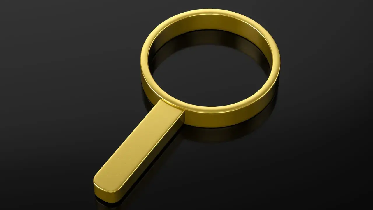 Lente d'ingrandimento in **oro 24 carati** su sfondo nero lucido, simbolo di ricerca preziosa.