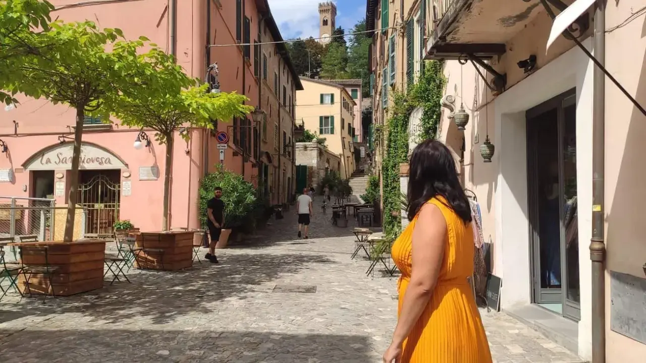 Un vicolo pittoresco con un campanile in lontananza, perfetto per scoprire cosa vedere vicino Rimini.