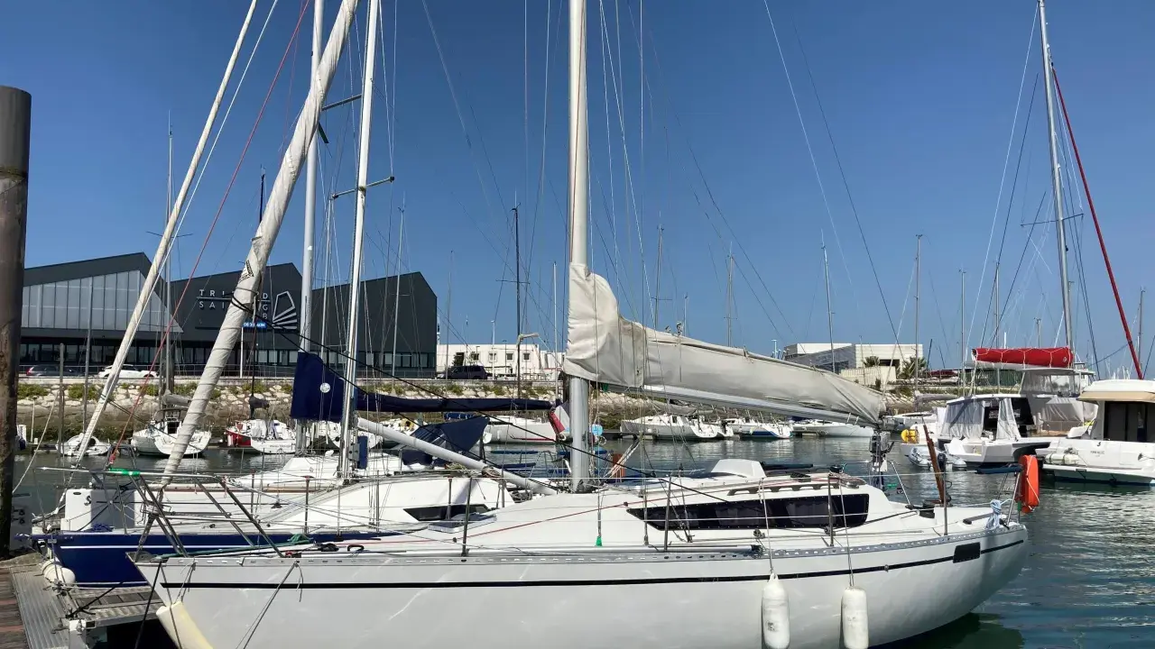 Voiliers blancs amarrés dans un port sous un ciel bleu. L'ambiance est paisible, feeling 920 avis.