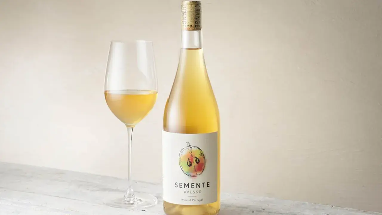 En flaska och ett glas med gyllene Semente Avesso vin.