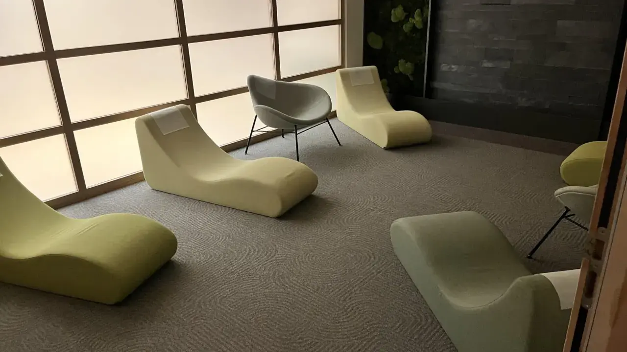 Un espace d'accueil moderne avec des chaises longues confortables et un mur végétal apaisant.
