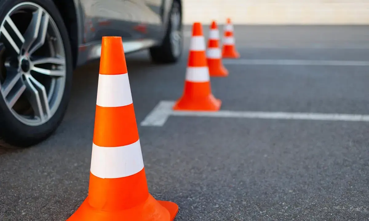Pomarańczowe pachołki na placu manewrowym. Zastanawiasz się, jakie prawo jazdy potrzebne na autolawetę?
