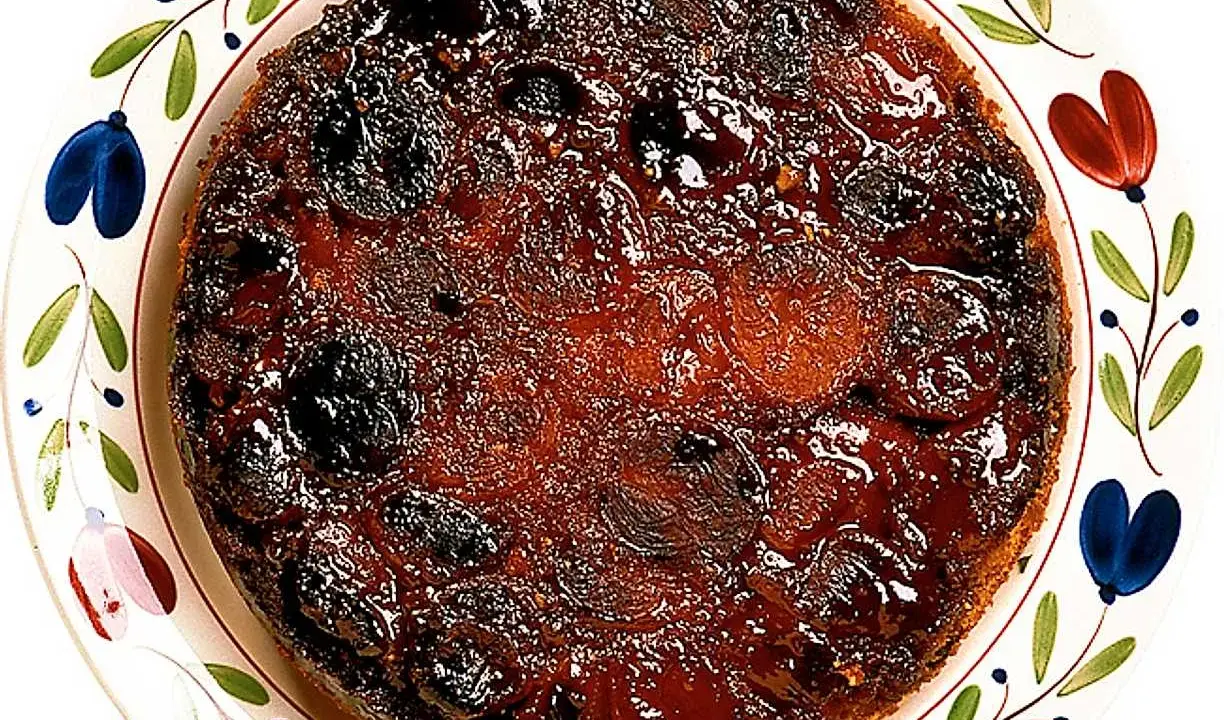 En härlig aprikoskaka upp och ner, med karamelliserad yta och saftiga aprikoser, serverad på en vackert dekorerad tallrik.