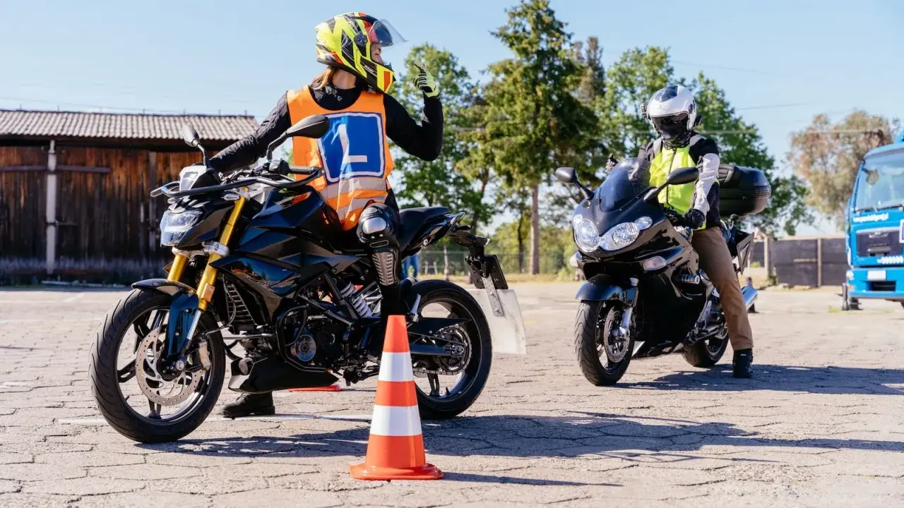 Nauka jazdy na motocyklu. Kursant w kamizelce z literą "L" i kasku na motocyklu, gotowy do zdobycia prawko na motocykl.