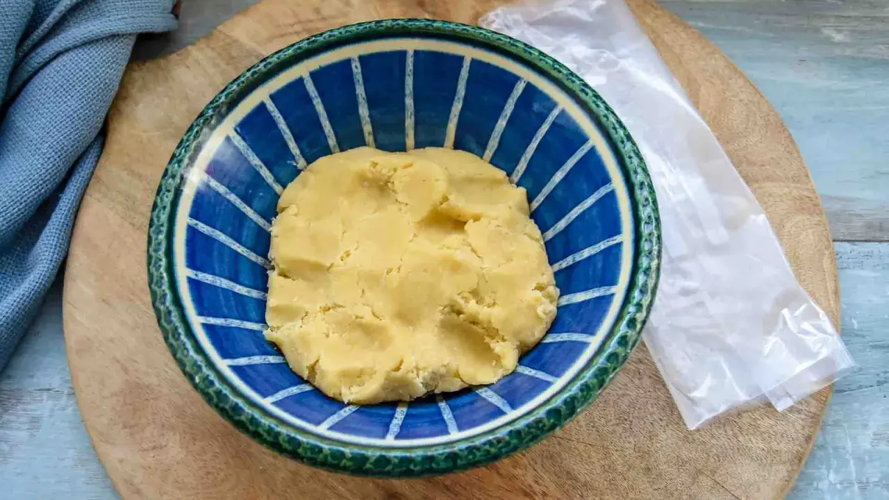 Frischer quiche teig in einer blauen Schüssel, bereit für die Zubereitung einer herzhaften Quiche.