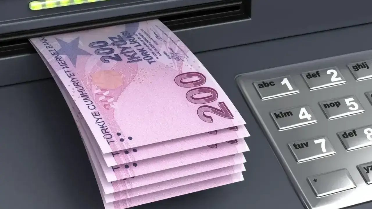 Stos banknotów po 200 lir tureckich wychodzi z bankomatu. To pokazuje, jakie pieniądze w Turcji można wypłacić.