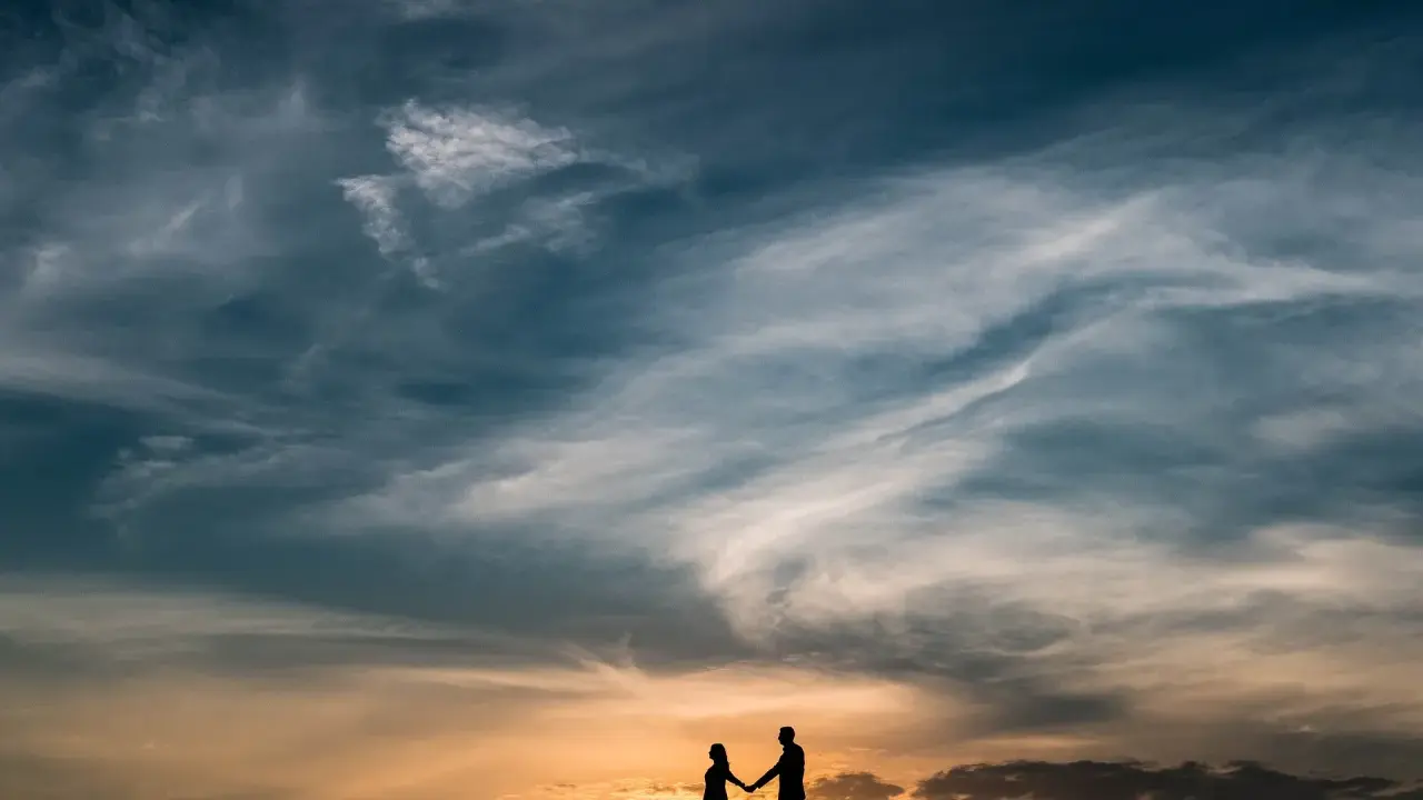 Coppia in silhouette al tramonto, un'immagine che evoca una poesia per 60 anni di matrimonio, un amore che dura nel tempo.