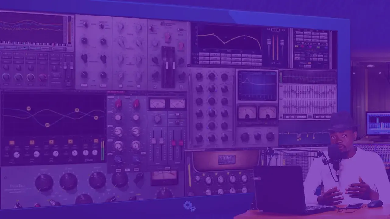 Un homme au chapeau parle dans un micro, entouré d'écrans affichant des logiciels pour faire des prods musicales.