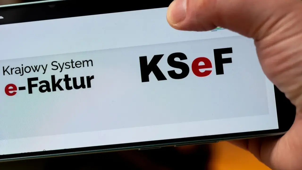 Palec dotyka ekranu telefonu z napisem "Krajowy System e-Faktur KSeF". To część polskiego ładu w finansach.